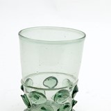 Noppenbeker, glas na 1550 - voor 1625. Berkemeier glas of noppenbeker, met getande standring en doornnoppen. Het glas is ongeschonden en helder. © Slot Loevestein, publiek domein.