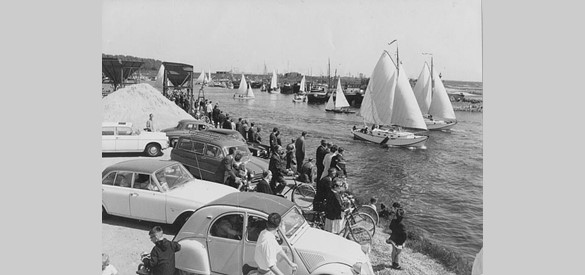 Vanaf de jaren ’60 groeide de recreatievaart sterk. Op deze foto uit 1965 kijkt publiek in de jachthaven van Tiel naar het vertrek van een zeilrace over de Waal naar Gorinchem. Ook elders werden zeilraces op de Waal georganiseerd.
