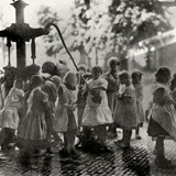 De schooljeugd lest de dorst bij de dorpspomp aan de Dorpsstraat in 1925. De pomp staat daar sinds 1862. De straatnaam 'Pompweg' herinnert aan de plek waar de dorpspomp heeft gestaan. Collectie G.G.Driessen.