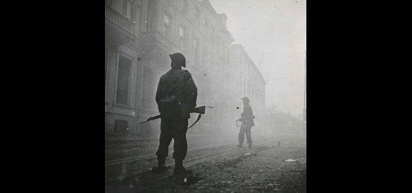 Britse militairen trekken op door de Utrechtsestraat onder dekking van een rookgordijn.