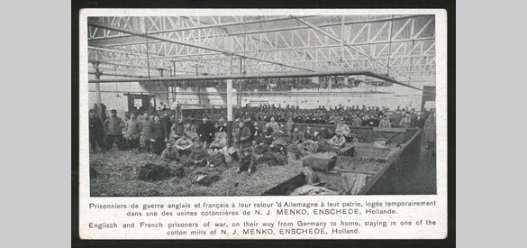 Foto van Duitse en Engelse krijgsgevangenen in fabriekshal te Enschede.