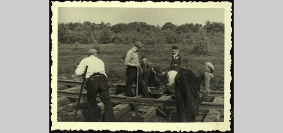 De aanleg van treinrails naar kamp Westerbork. De zogenaamde 'jodenster' op de kledij van een van de mannen wijst erop dat dit door joodse dwangarbeiders gebeurde (1942).