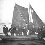 De veerboot die begin van de vorige eeuw tussen Bemmel en Ooij voer. De man met de vaarboom, tweede van links, is de zoon Looijschelder. © Collectie W. Ebben