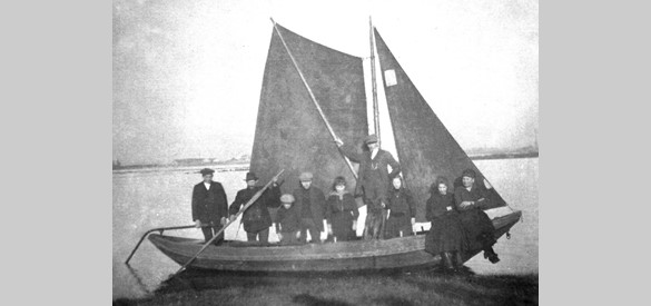 De veerboot die begin van de vorige eeuw tussen Bemmel en Ooij voer. De man met de vaarboom, tweede van links, is de zoon Looijschelder.