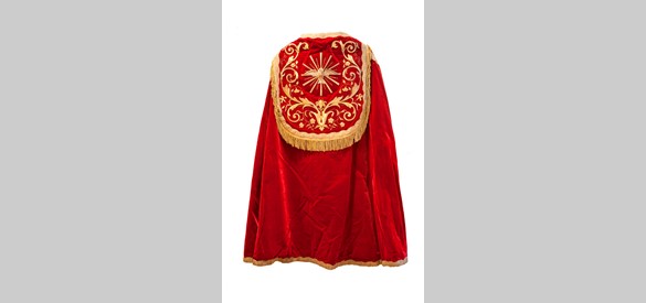 De rugzijde van een liturgische mantel van rood velours, uit het midden van de negentiende eeuw.