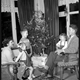 Kerst, zingen bij de kerstboom. Jaartal onbekend, waarschijnlijk jaren zestig. © 