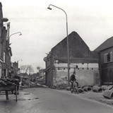 Werkzaamheden tijdens de verbreding van de Oosterstraat, 1961. De nieuwbouw is al zichtbaar achter de oude rij huizen. Begin 1962 zijn alle panden gesloopt en kan de nieuwe weg worden aangelegd (foto: Archief Stichting Oud Nijkerk).