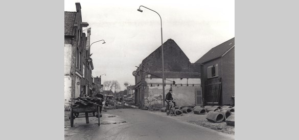 Werkzaamheden tijdens de verbreding van de Oosterstraat, 1961. De nieuwbouw is al zichtbaar achter de oude rij huizen. Begin 1962 zijn alle panden gesloopt en kan de nieuwe weg worden aangelegd (foto: Archief Stichting Oud Nijkerk).