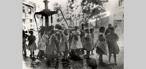 De schooljeugd lest de dorst bij de dorpspomp aan de Dorpsstraat in 1925. De pomp staat daar sinds 1862. De straatnaam ‘Pompweg’ herinnert aan de plek waar de dorpspomp heeft gestaan.