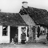 In de crisisjaren heerst er veel armoede. Slechte huizen en hongerige kinderen zie je in veel buurten. De foto is gemaakt in 1933 in de Dukenburg (Breedeweg). © Collectie G.G. Driessen, CC-BY-NC