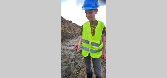 Jongste vrijwilliger Ber Smole met zijn eerste vondst een Romeinse mantelspeld.