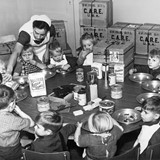 Een verpleegster voedt Nederlandse kinderen uit CARE-pakketten, circa 1953. © Bron: CARE.