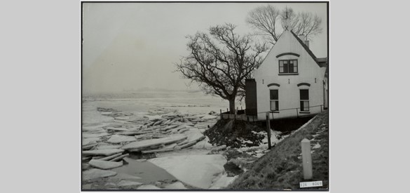 Dijkhuisje bij Rossum na de strenge winter van 1956. Het kruiend ijs van de Waal werkt zich tegen de dijk op.