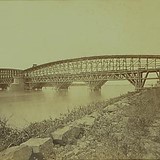 De spoorbrug over de Waal bij Zaltbommel in aanbouw in 1869. Er is nog een onderbrug te zien ten behoeve van de werkzaamheden. © Wikimedia Commons, Pieter Oosterhuis - PD