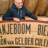 Egbert Ausems bij het reclamebord voor Oranjeboom Bier © Elisabeth Weeshuis Museum. Foto: Roelien van Neck