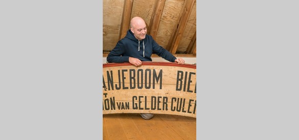 Egbert Ausems bij het reclamebord voor Oranjeboom Bier