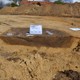Er is een coupe door de resten van een hutkom gezet. © VUhbs Archeologie