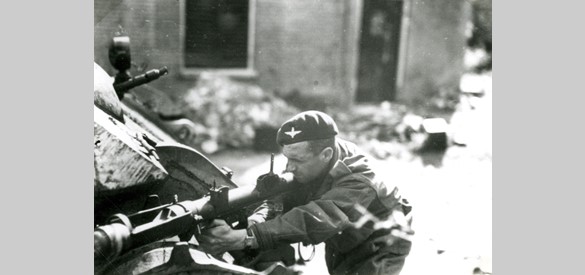 Een Britse militair in actie met een PIAT, vanachter een Königstiger tank, Weverstraat, Oosterbeek. De foto werd gemaakt tijdens opnamen van de film Theirs is the Glory (over de Slag om Arnhem, september 1944), in de zomer van 1945