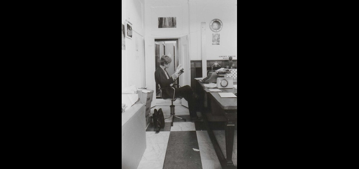 Archiefkluis in de bodekamer van het stadhuis. Voor de kluisdeur archivaris Henk Huitsing, 1980. Collectie Regionaal Archief Rivierenland, Tiel