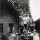 Personeel van schoenfabriek 'De Ooievaar' aan de Kerkstraat poseert op de trap van de fabriek in 1925. Onder de arbeiders zijn kinderen die net van de lagere school komen. Collectie G.G.Driessen.