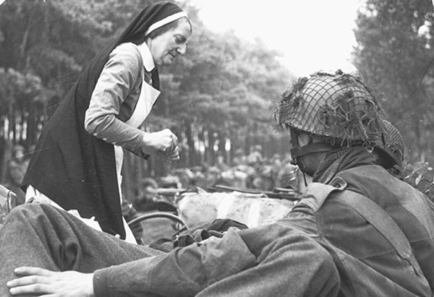 Een Nederlandes verpleegster helpt gewonde Britse para’s bij Oosterbeek (Bron: Stichting Liberation Route Europe, © Beeldbank WO 2 – NIOD)