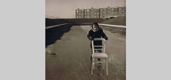 Hans op de schaats, met op de achtergrond de flat aan het Immerlooplein