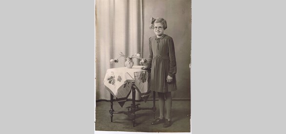 Dit is Annie in 1942. In deze kleding van de St. Vincentiusvereniging deed ze haar plechtig aannemen. Ze schaamde zich voor deze jurk, iedereen droeg hem. Moeder heeft het kraagje iets veranderd en de taille en zoom geborduurd.