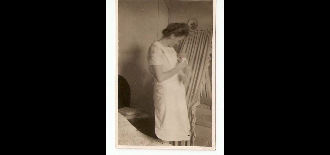 Baker met baby en wieg op de kamer van de ouders, ca. 1950