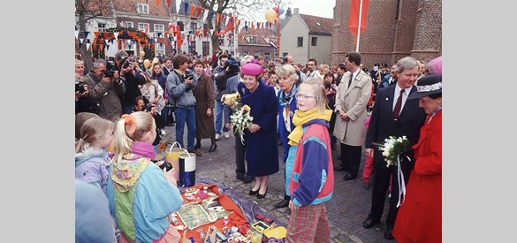 Koningin Beatrix (midden) en prinses Margriet (rechts) bekijken de artikelen op de vrijmarkt, tijdens Koninginnedag 1991 in Culemborg (Foto: ANP )